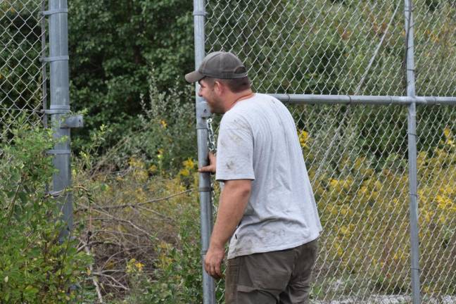 Connor Smith shuts and padlocks the gate after an August workday. Opening the park to the public, he said, will be a huge challenge.