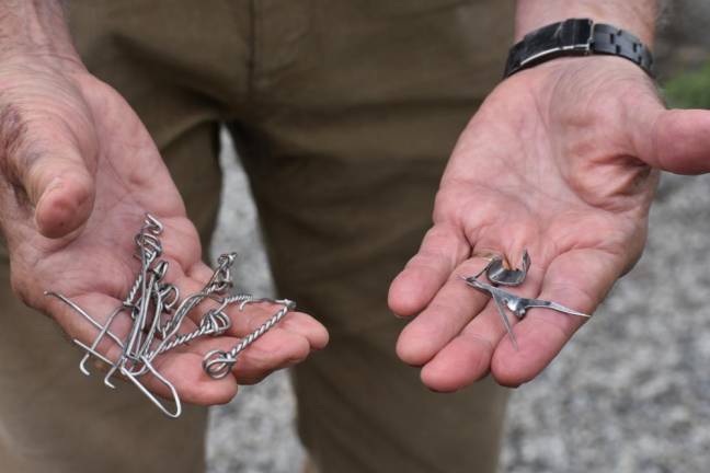 Geoff Howard holds metal shards and twists, remnants of the barbed wire fencing, that he picked up on the short walk out of the park.