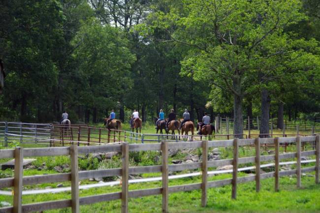 A group of clients heading out on the trails on horseback.